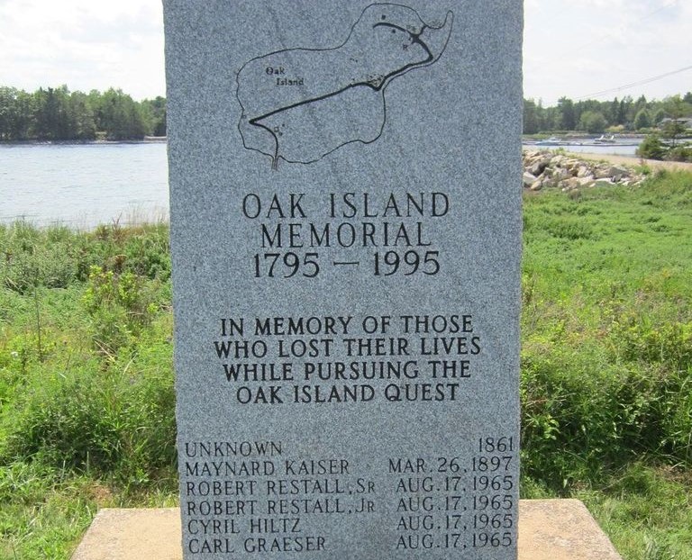 A picture of a memorial stone on Oak Island with the first death listed as unknown